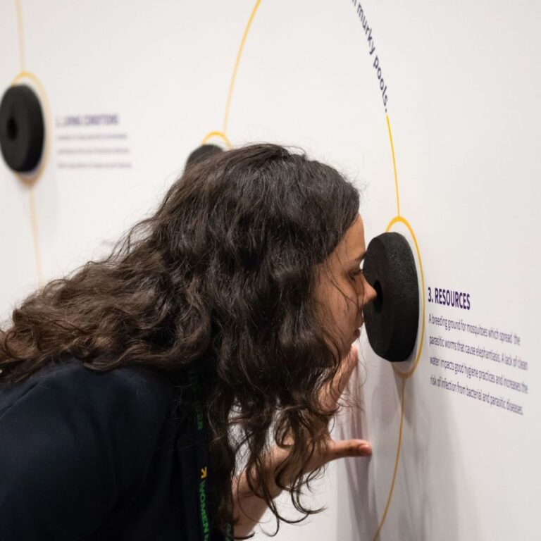 Women Deliver 2019 - a woman trying out the smell wall at an experiential event.