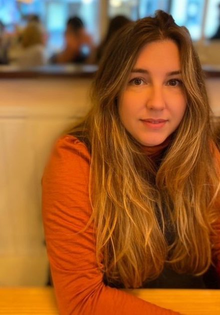 Rachel Jenkins from Action For Children, she is sitting down, wearing an orange top and has long golden brown hair